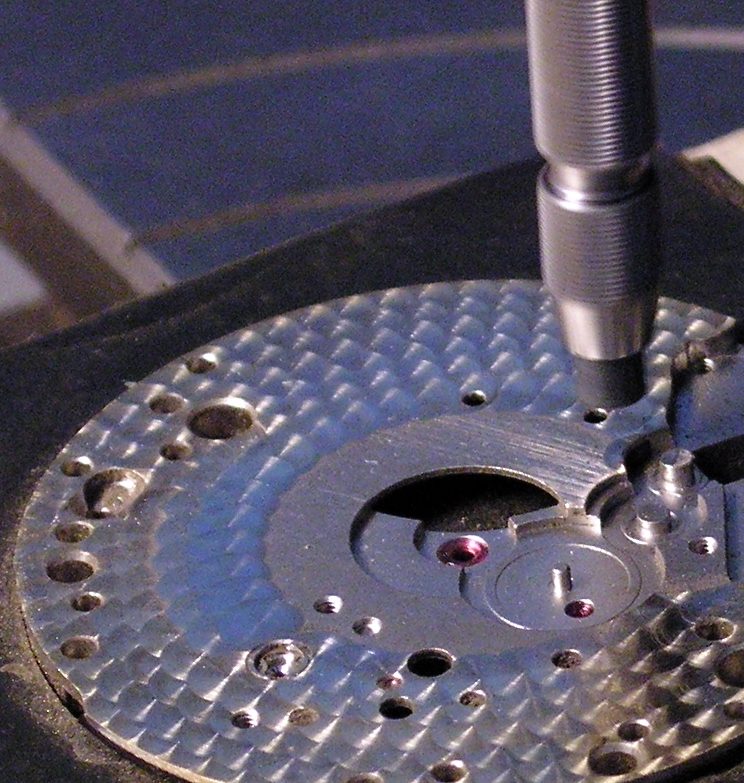 Finition perlée d'un platine de mouvement horloger, artisanat de précision